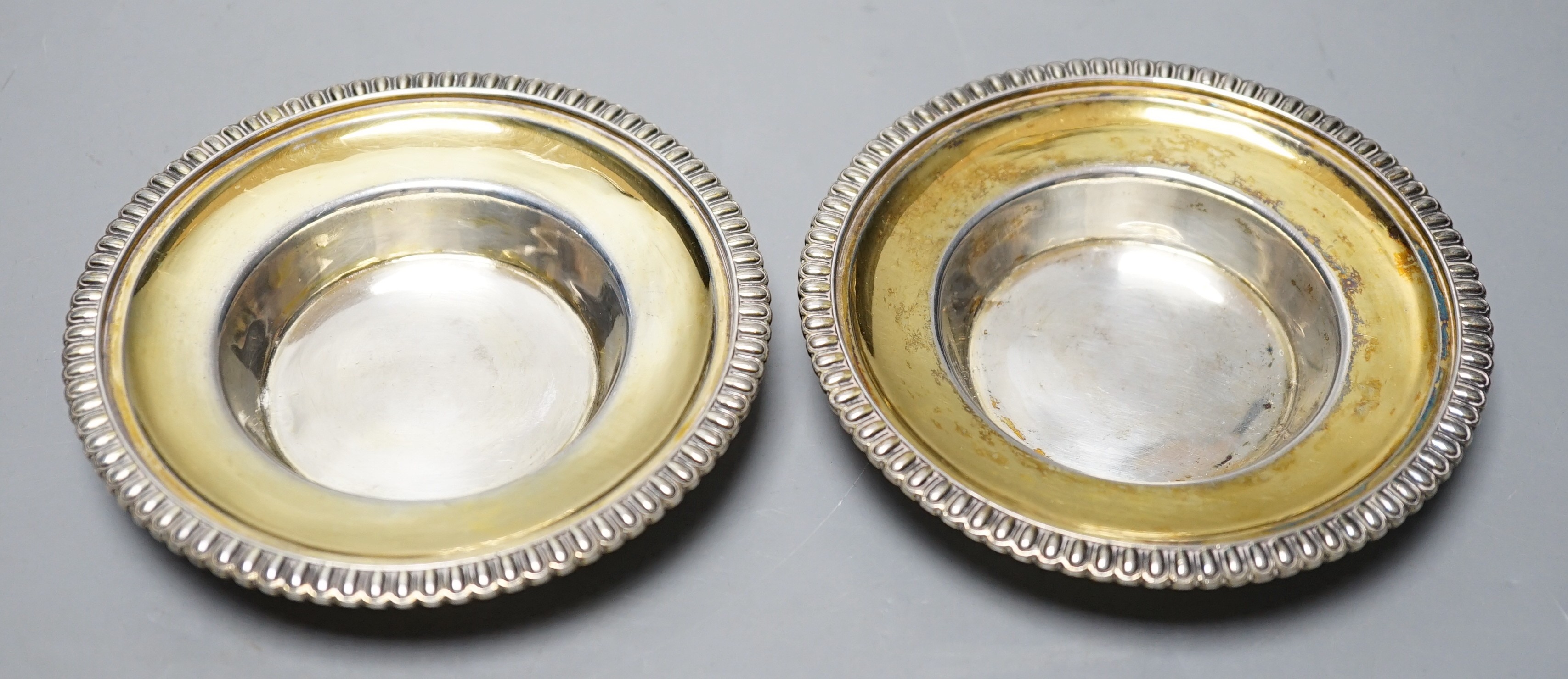 A pair of George III parcel gilt silver circular stands, with gadrooned borders, Emes & Barnard, London, 1814, 11cm, 5.4oz.